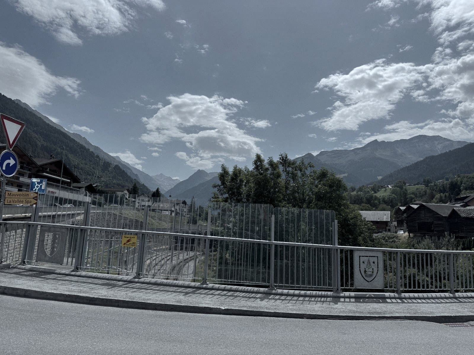 Les voies du Saint-Bernard Express en tranchée à l'entrée du village, parois vitrées et mazots au-dessus.